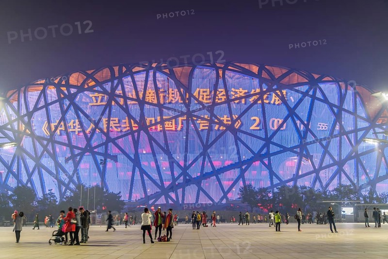 People on square in front of illuminated National Stadium in the Olympic Park