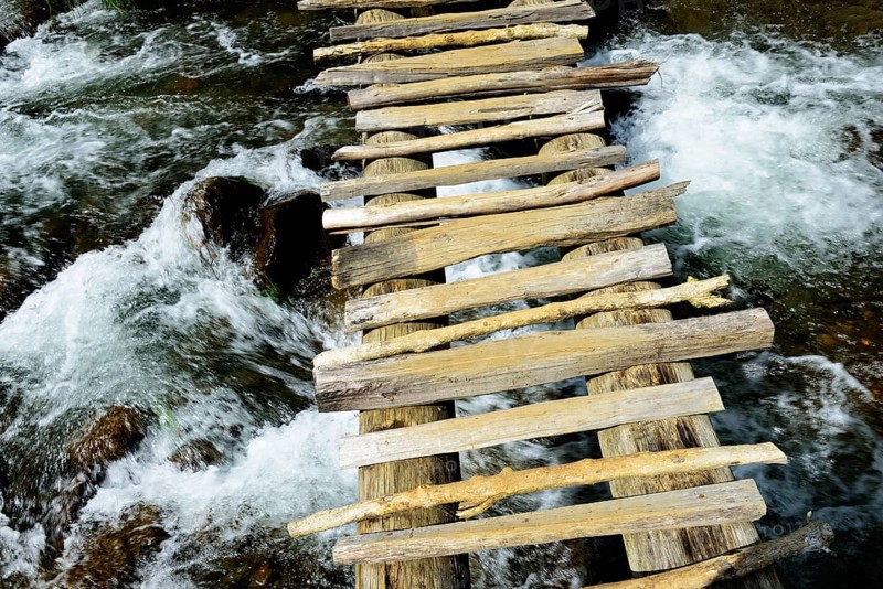 Simple wooden bridge over river