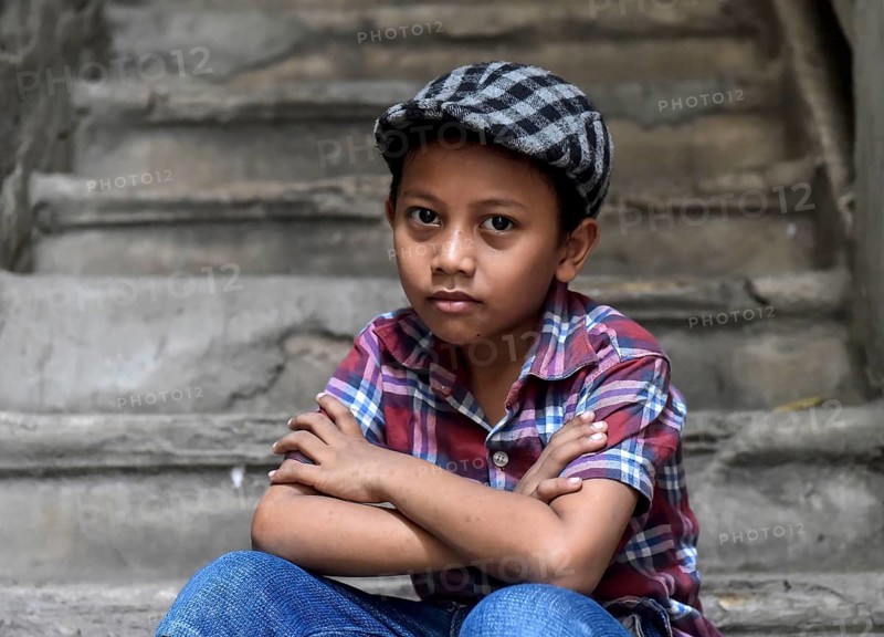 Boy on staircase with shirt and flat cap