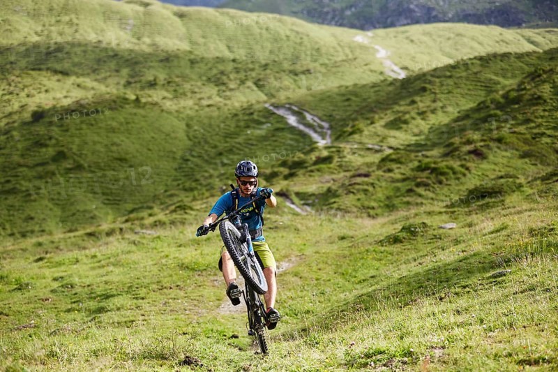 Mountain Biker rides a trail in the hilly landscape