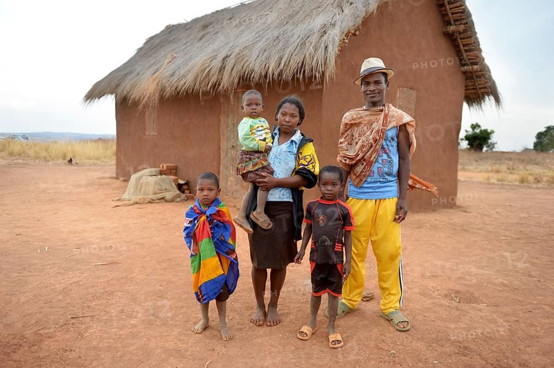 Family with three children in front of hut