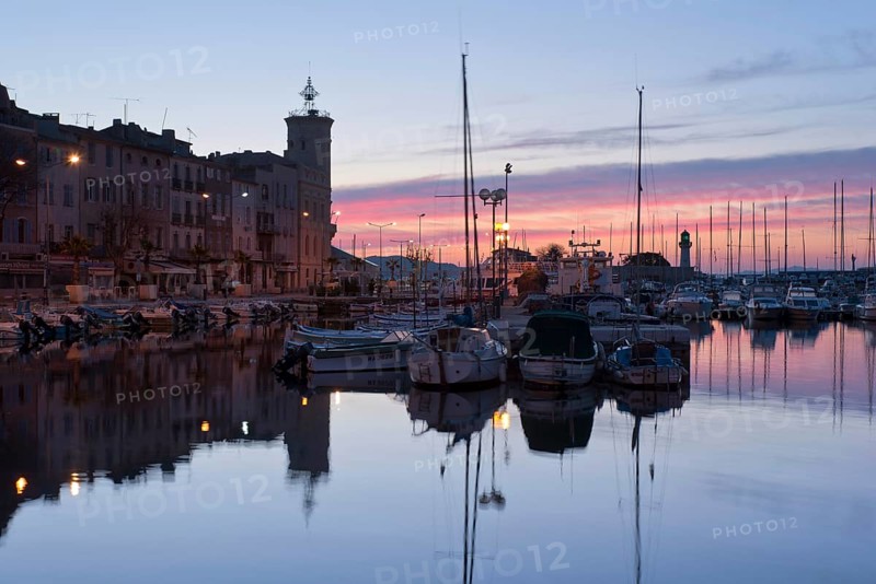 Old city with boats in the harbour at sunrise