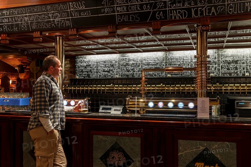 Man holding a glass of beer at Olhallen
