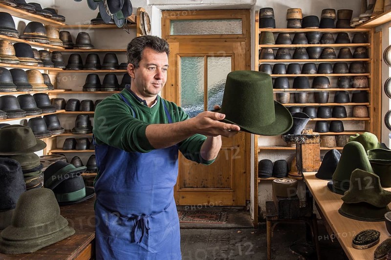 Hatter examining finished wool felt hat