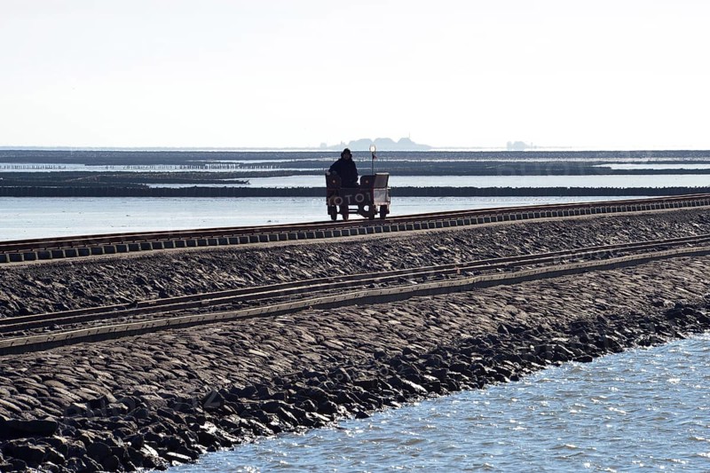 Wagon rolling over dam in Wadden Sea