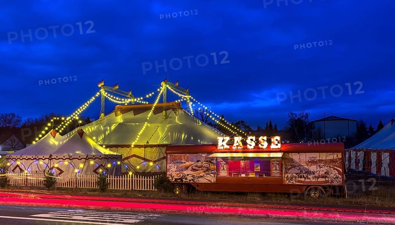 Travelling circus with counter illuminated at dusk