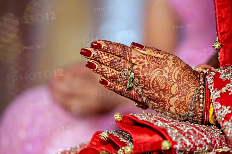 Traditional bridal jewelry and henna decoration on the hands of the bride during a religious ceremony at a Hindu wedding
