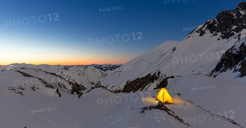 Illuminated tent in the snow on the Madelejoch