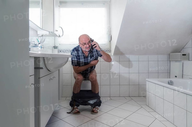 Senior man sitting on the toilet