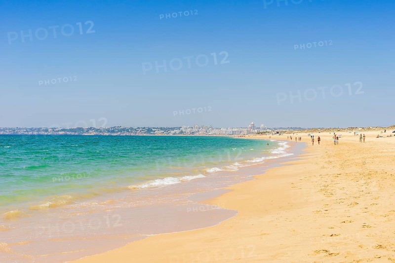 People relaxing on the beach next to Armacao de Pera