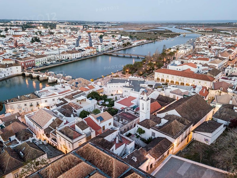 City view with roman bridge over Gilao river in old fishermen's town in the evening light