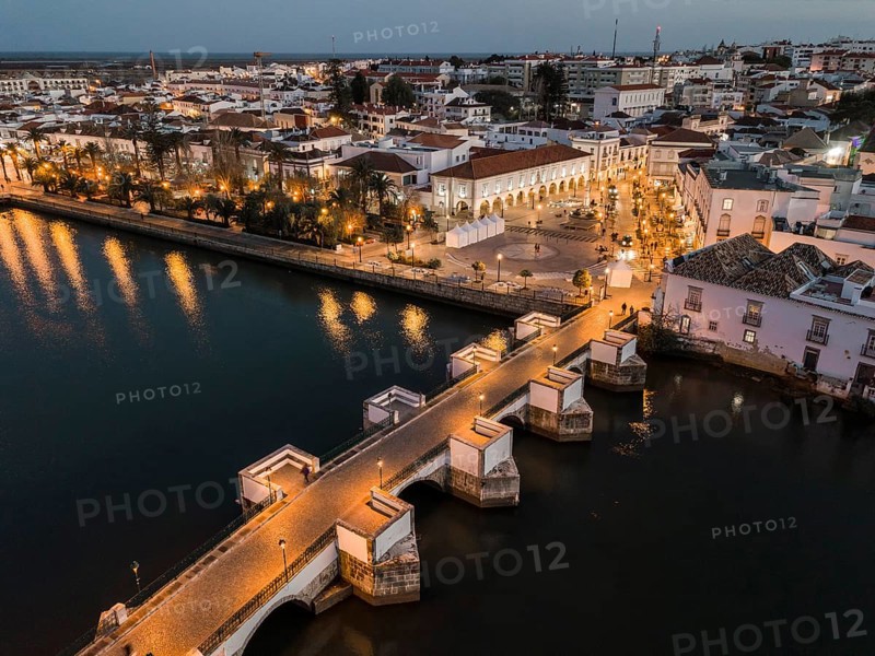 City view with roman bridge over Gilao river in old fishermen's town in the evening light