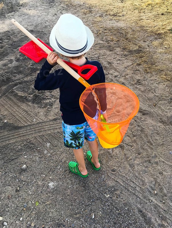 Boy with a fishing net on the beach