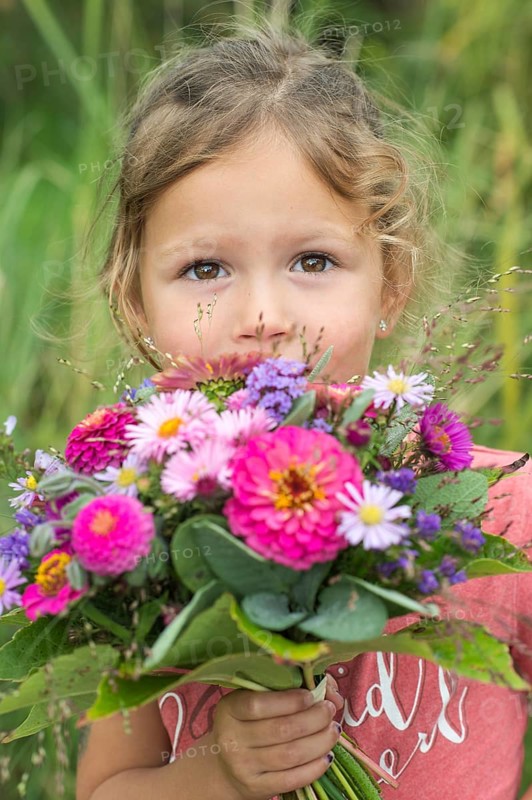 Little girl holding autumn bouquet with Zinnia (Zinnia elegance)