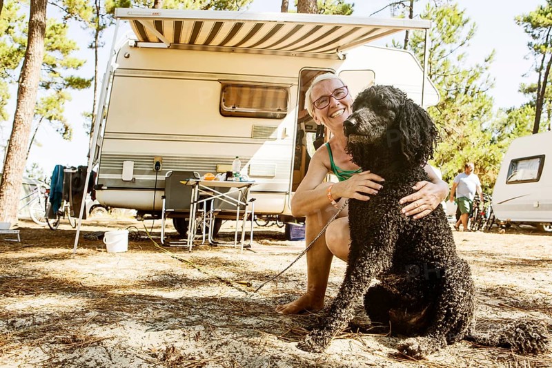 Woman squats laughing with her dog