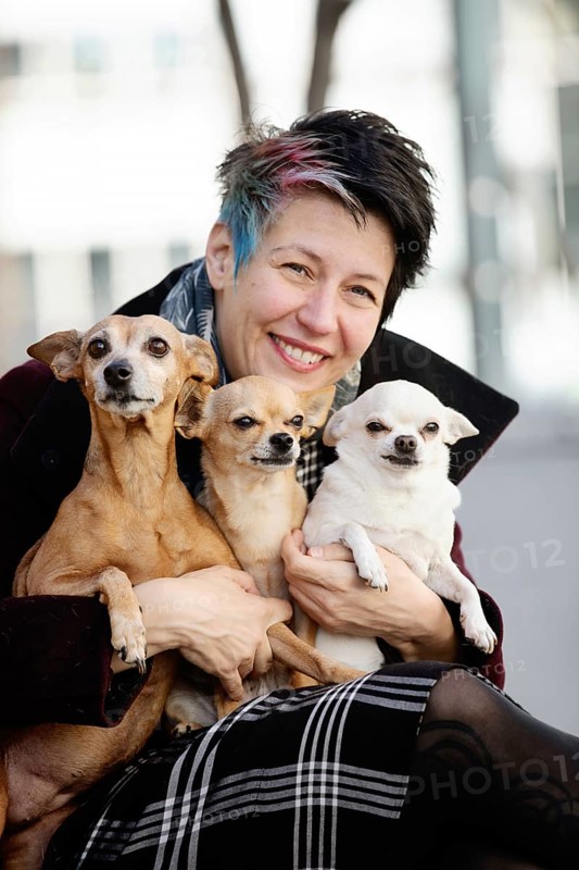 Woman with her three dogs on her lap