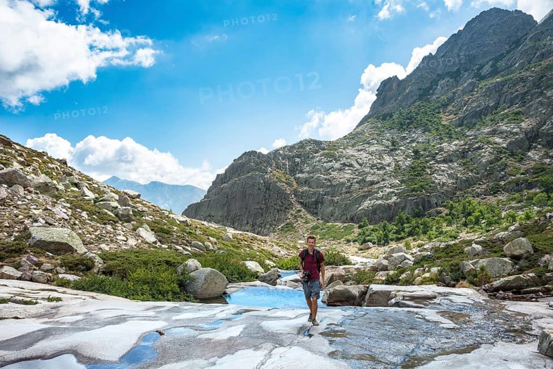 Young man hiking by the river Golo in the mountains