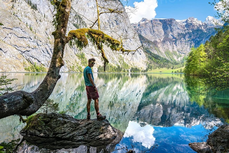 Young man standing on stone in water