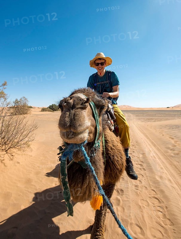 Young man riding on a camel