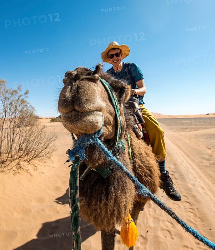Young man riding on a camel