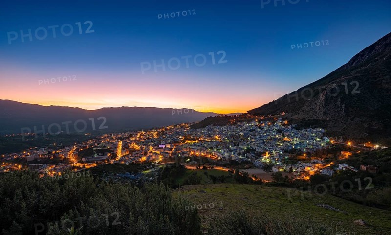 View of illuminated city Chefchaouen at sunset