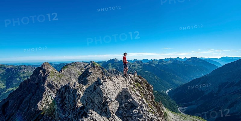 Hiker stands on rocks looking into the distance