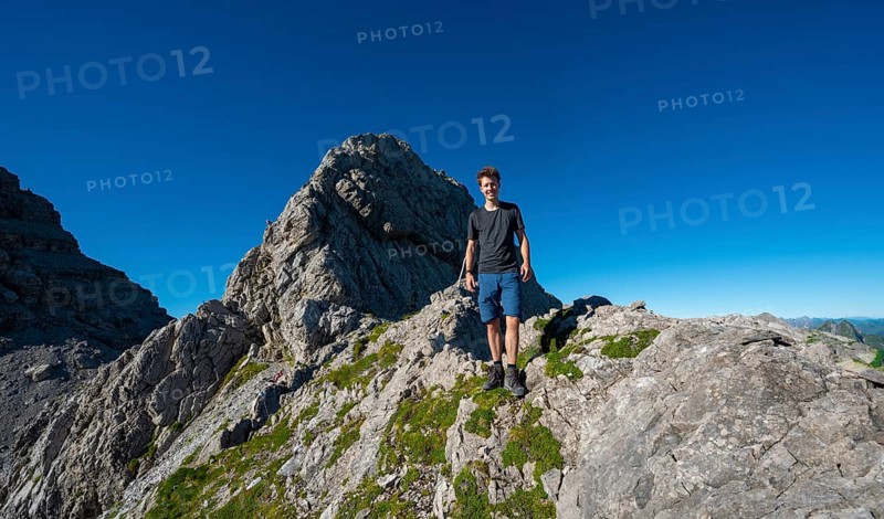 Hiker at the saddle at the Kreuzspitze