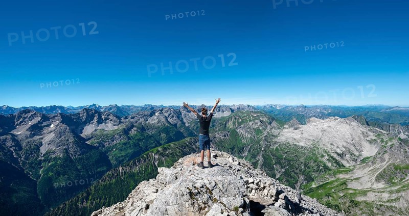 Hiker stretches arms into the air