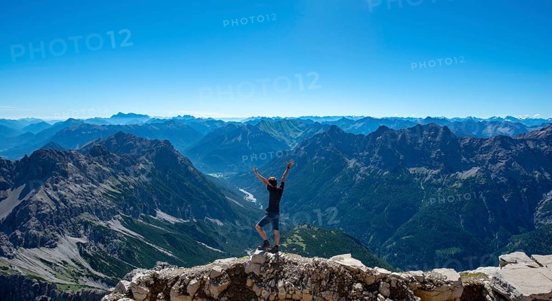 Hiker stretches arms into the air
