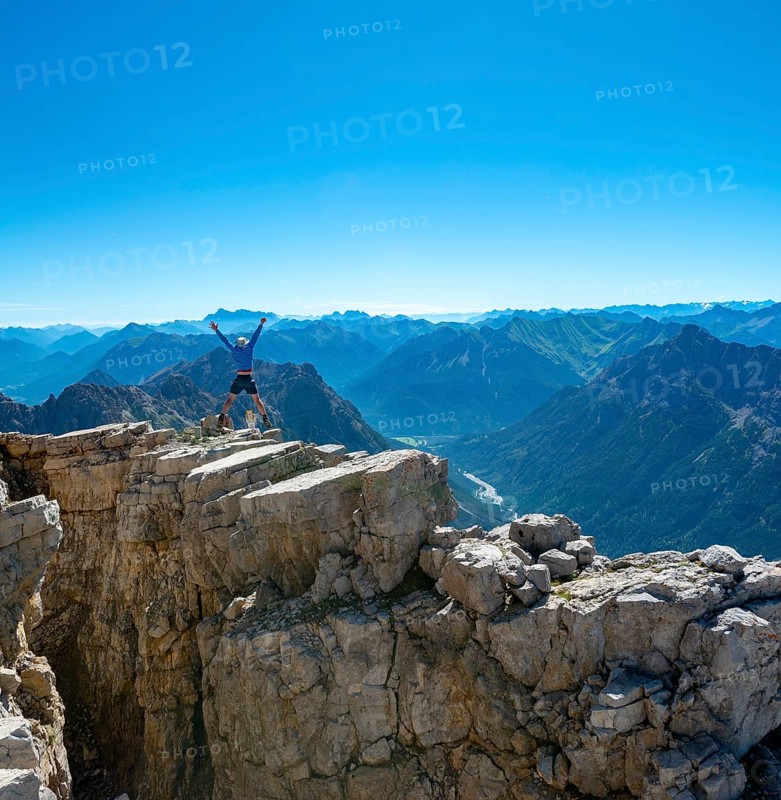 Hiker jumps and stretches arms into the air