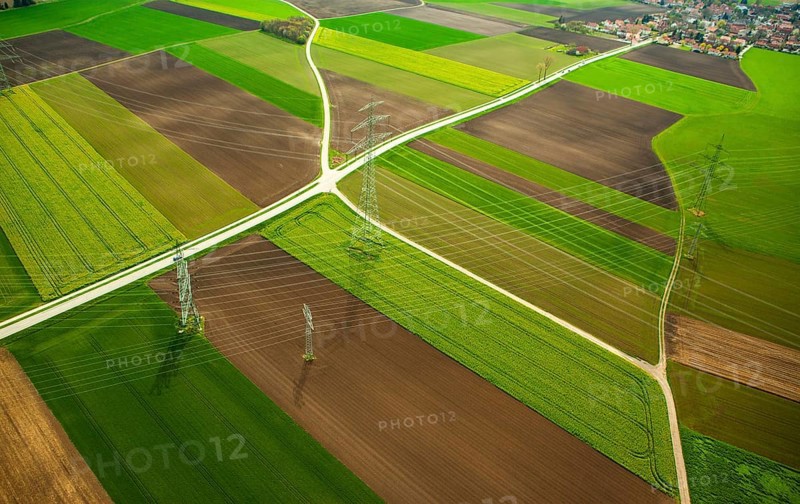 High-voltage transmission lines over farm fields in spring