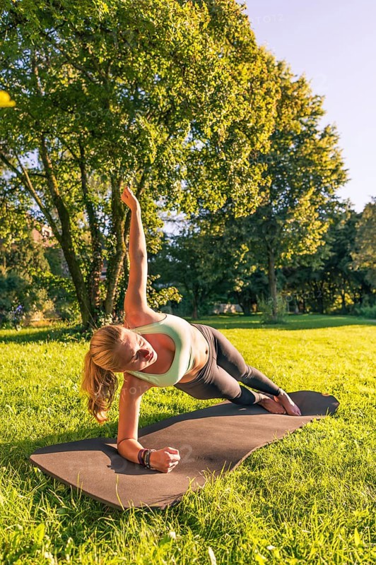 Young woman in sportswear doing side plank