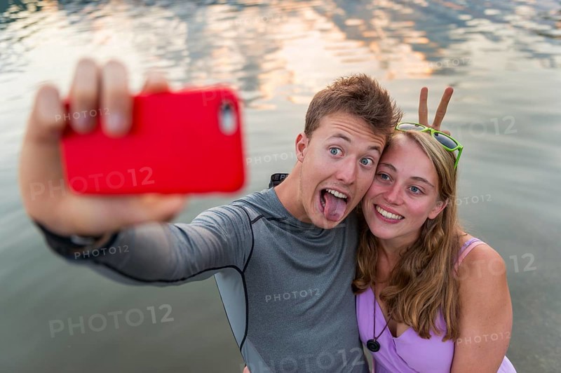 Young couple photographing themselves with mobile phone