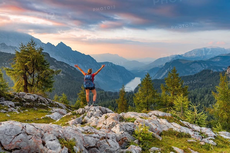 Hiker stretches arms into the air