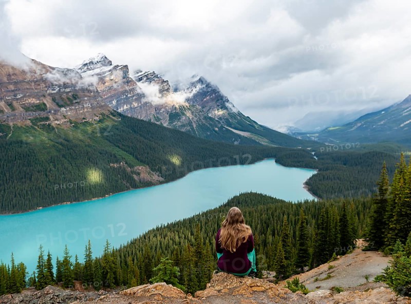 Young woman sitting on a stone looking into nature