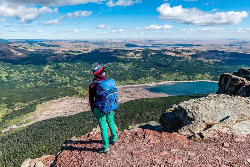 Young hiker standing at the view of mountain lake Lower Two Medicine Lake with mountain landscape