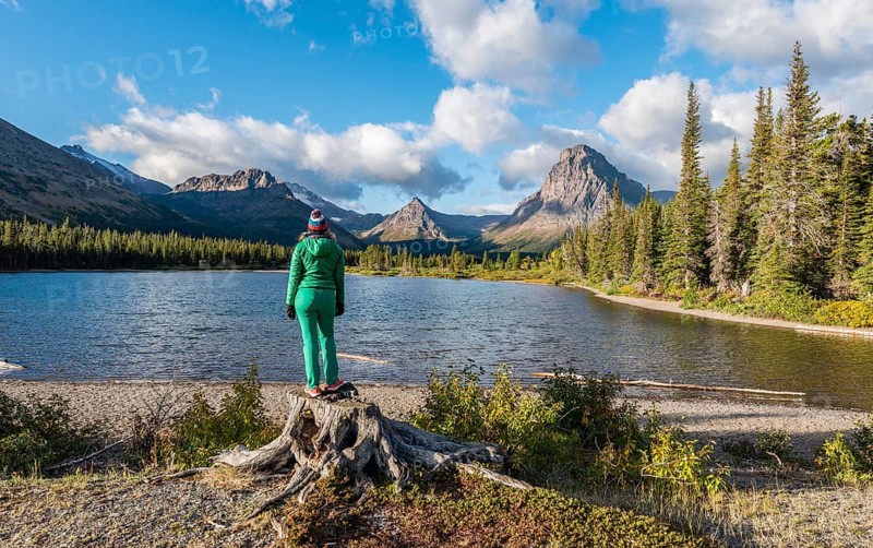 Young woman looking at mountain lake Two Medicine Lake in mountain landscape