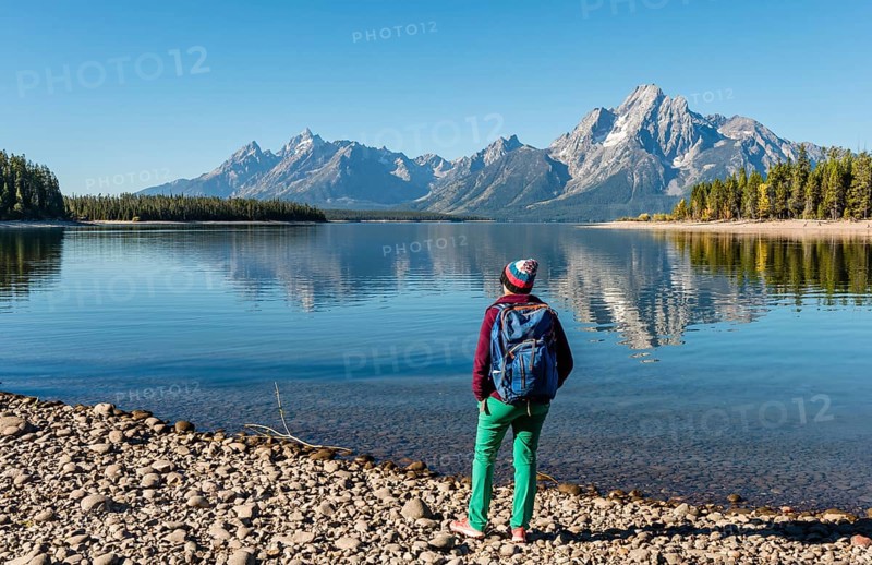 Young woman with rucksack standing on the shore