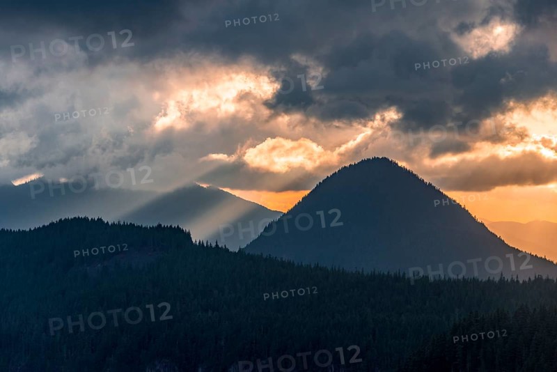 Hilly wooded mountain landscape at sunset with dramatic clouds