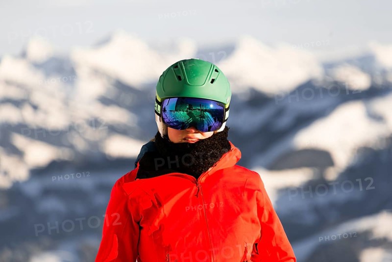 Female skier with ski helmet and ski goggles looks into the camera