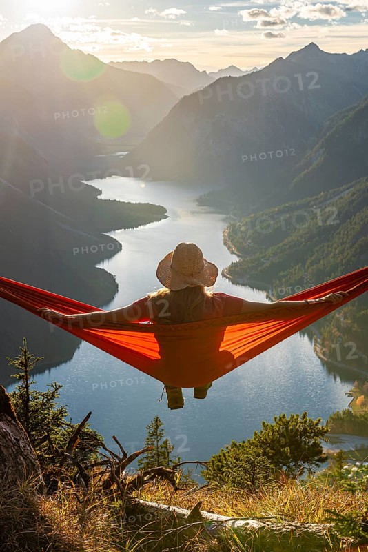 Woman with a sun hat sitting in an orange hammock