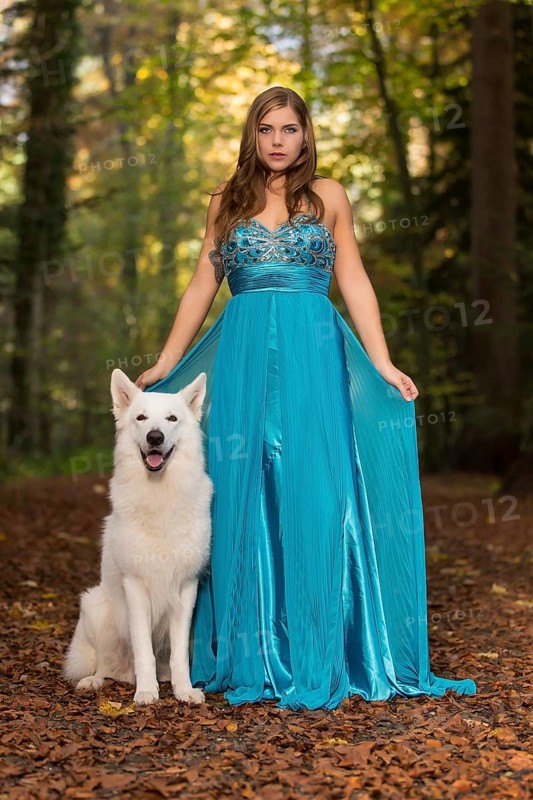 Woman with long turquoise-blue evening dress and white shepherd dog