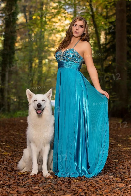 Woman with long turquoise-blue evening dress and white shepherd dog
