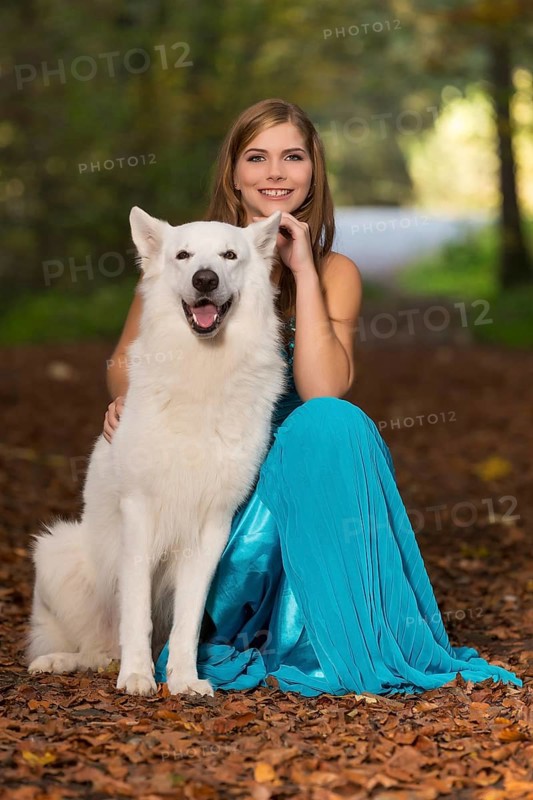 Woman with long turquoise-blue evening dress and white shepherd dog