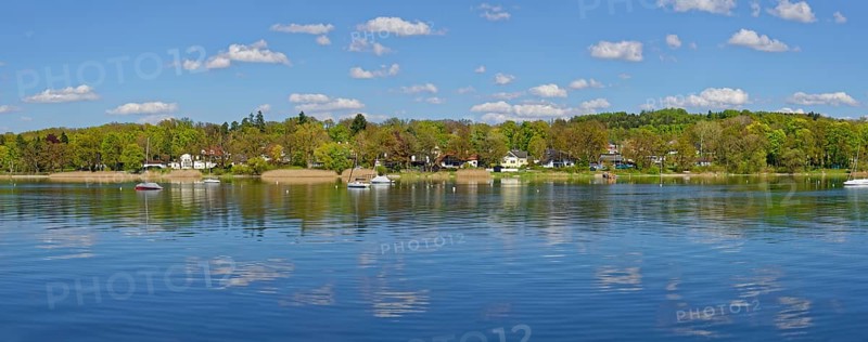 Lake Ammerufer near Herrsching with water reflecting cumulus clouds