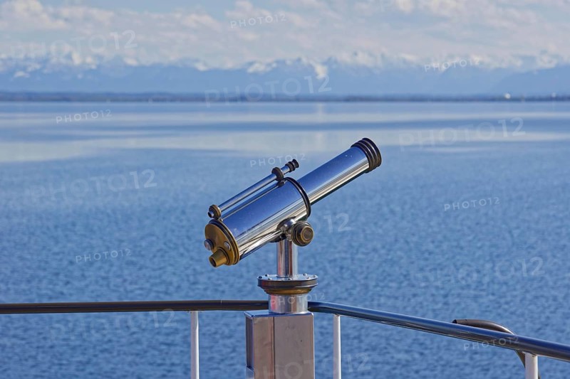 Binoculars with view to the snow-covered alpine peaks