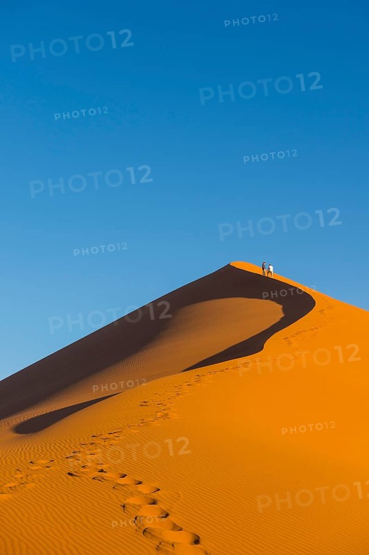 Woman walking up the giant sanddune Dune 45