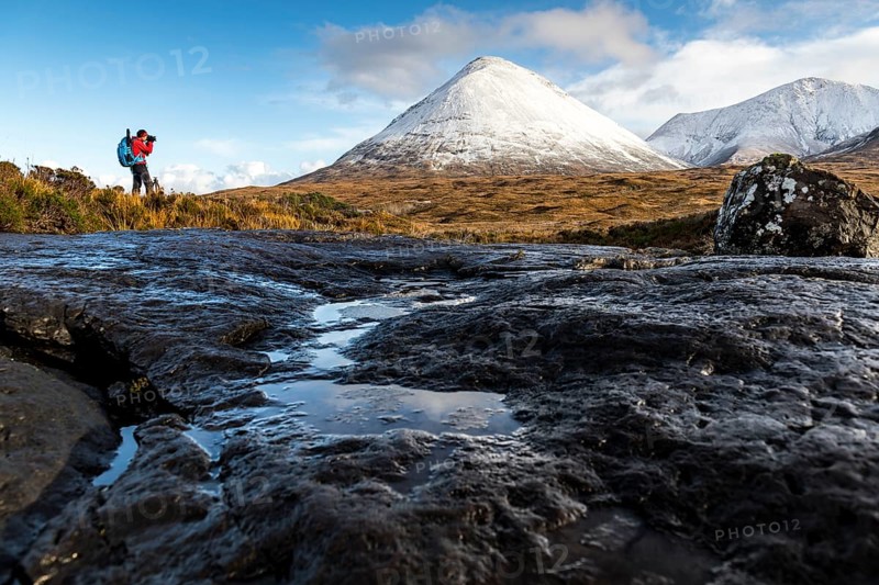 Photographer with snow-covered peaks of the Cullins Mountains