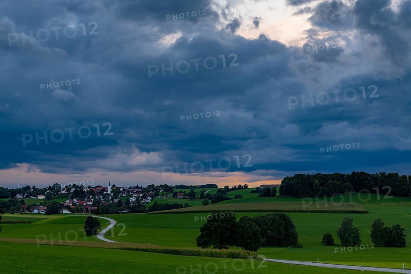 Thunderstorm sky with small village and meadows landscape