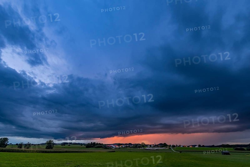 Thunderstorm sky with small village and meadows landscape